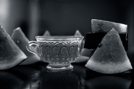 西瓜冰西瓜冰摄影照片_西瓜种子水果冰茶在木质表面的透明玻璃杯中，还有三角形的西瓜片。