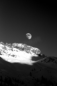 冬季山上月亮的黑白图像。