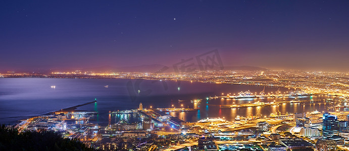 从南非信号山日落后，开普敦城市和港口的风景在夜间被照亮。