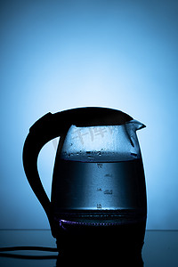蓝色背景上的电玻璃茶壶