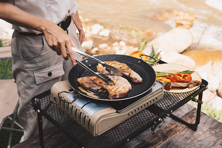 猪肉荠菜摄影照片_在夏令营旅行的露营地特写烧烤，在露营的烧烤派对上串猪肉和牛肉片，夏令营旅行一项放松活动。
