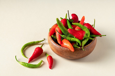 红绿辣椒摄影照片_木碗中的有机新鲜红绿辣椒