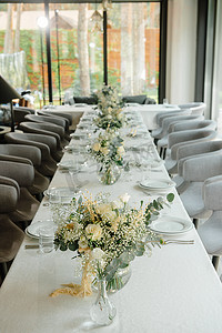 餐厅的婚宴桌上装饰着白色的蜡烛和鲜花。