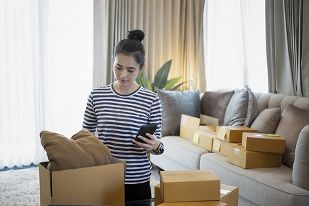 确认订单摄影照片_小企业主在家工作时通过手机确认客户的订单。