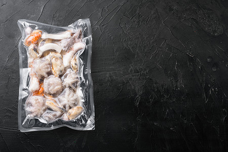 生海鲜、贻贝、真空包装的鱿鱼章鱼，黑色深色石桌背景，顶视图平躺，带文本复制空间
