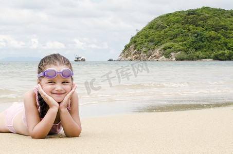 快乐的小女孩躺在沙滩上的沙滩上
