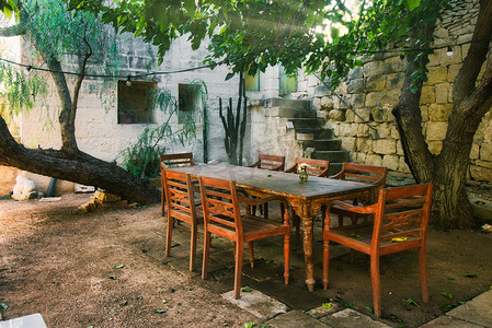 地中海花园户外的老式木制餐桌和椅子