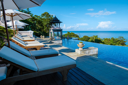 沙滩椅摄影照片_泰国兰达岛，泰国一家豪华酒店游泳池旁的豪华沙滩椅