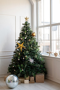明亮通风的客厅里放着礼物和灯的圣诞树
