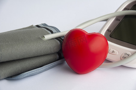 白色背景下的数字血压监测仪和心脏形状