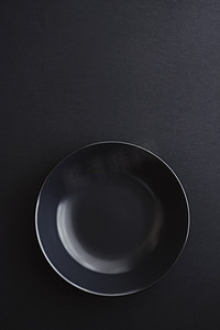黑色极简摄影照片_黑色背景的空盘子、假日晚餐的优质餐具、简约的设计和饮食
