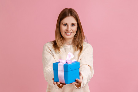 快乐的金发女人手里拿着包装好的礼盒，送礼物，祝贺朋友生日