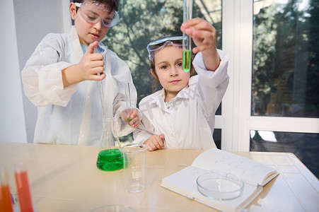 美丽聪明的白人学童使用实验室器具，在学校实验室的化学课上做化学实验