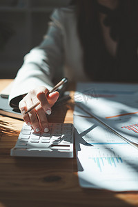 关闭女商人使用计算器在办公室、税务、会计、统计和分析研究概念的木桌上审计财务预算。