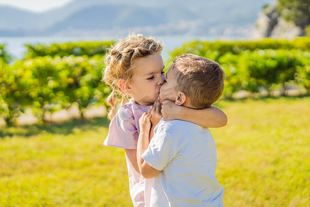 两个可爱的小孩子互相拥抱和亲吻的肖像，童年概念中的爱情友谊，永远最好的朋友