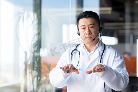 严肃而专注的亚洲医生从诊所打视频电话，办公室里的一名男子