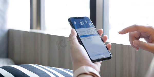 泰国清迈，20122 年 7 月 12 日：一名女子手持 iPhone X，屏幕上显示社交互联网服务 Facebook。