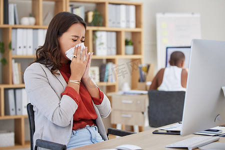 流感摄影照片_在办公室工作时生病、生病和打喷嚏的女商人患有感冒、流感或过敏。