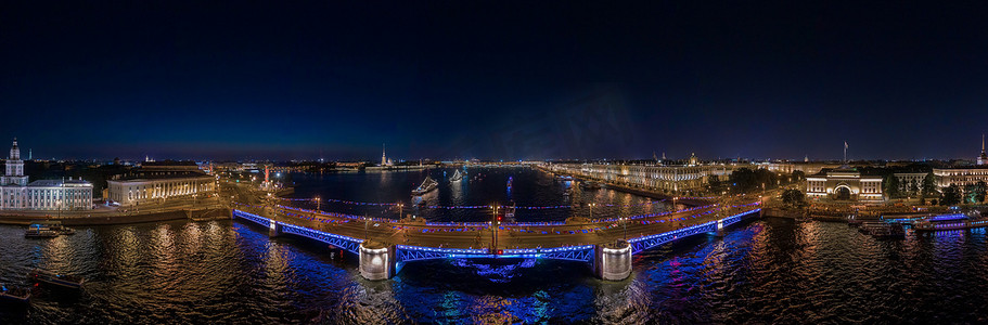 汽车天线摄影照片_俄罗斯海军节庆祝活动的夜景，建筑物、军舰和吊桥的夜间照明如画，许多人在没有汽车交通的情况下行走