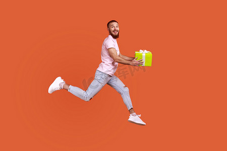 买送摄影照片_男人在空中跳跃或快速奔跑去送礼盒，表达幸福。