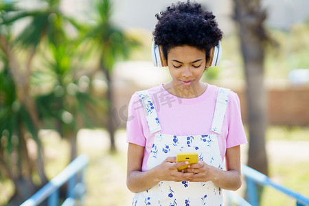 黑人女性一边浏览智能手机一边听音乐