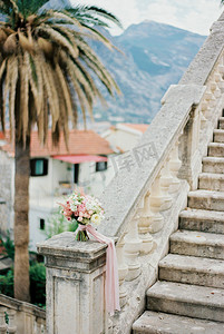 粉色台阶摄影照片_台阶附近的大理石栏杆上矗立着一束鲜花