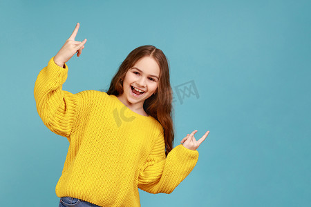 快乐疯狂的小女孩做摇滚手势的肖像，用手展示酷炫的摇滚标志。