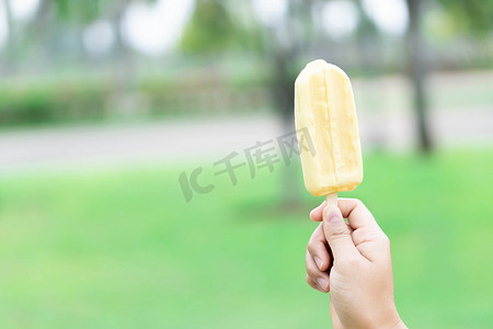 自然花园背景下的女人手拿着冰淇淋