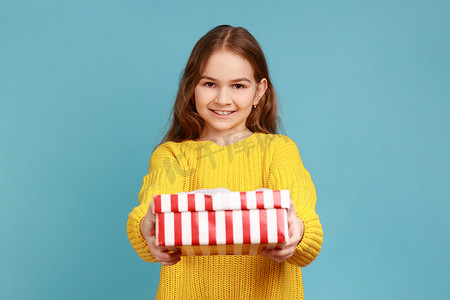 小女孩微笑着给镜头送礼盒，孩子们在假期问候并分享礼物。