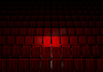 娱乐电影摄影照片_一排排红色天鹅绒座椅在电影院里看电影，聚光灯下只有情侣豪华座椅背景。