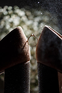订婚背景摄影照片_婚礼当天新娘的订婚戒指和漂亮的节日鞋