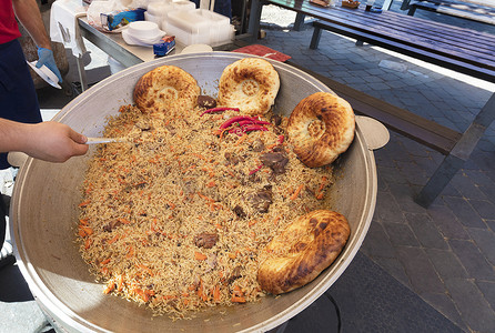大街上背景摄影照片_美味的抓饭是在街上用大锅煮的