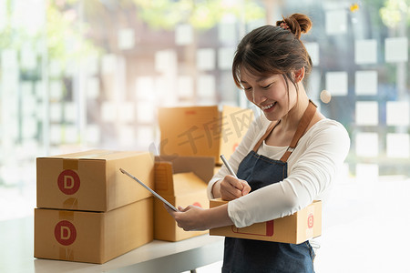 年轻的亚洲小企业主在家办公，记录采购订单。