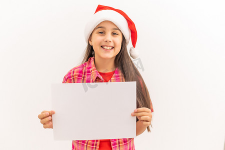 免费圣诞摄影照片_圣诞女孩手里拿着空的水平空白，站在上面，与白色隔离