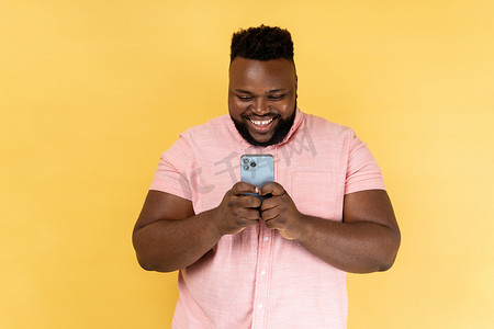 沉迷手机摄影照片_男人用手机表情快乐，沉迷于智能手机，在社交网络中发短信。