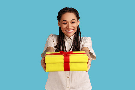 买送摄影照片_快乐的女人，留着黑色长发绺，送出包装好的礼品盒，对着镜头或送货微笑。