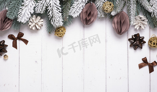 平铺背景图摄影照片_节日创意圣诞组合物，配有松树、纸圣诞球和其他装饰平铺在木质背景上