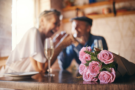 香槟玫瑰花摄影照片_爱情、庆祝和玫瑰的情侣结婚纪念日，还有香槟祝酒。