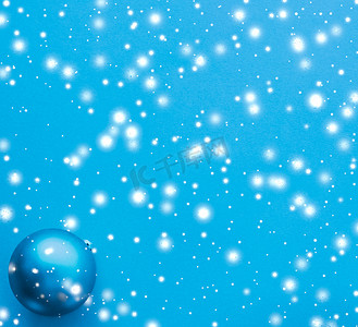 蓝色冬日雪花摄影照片_蓝色背景的圣诞小玩意，雪花闪闪发亮，豪华冬日贺卡