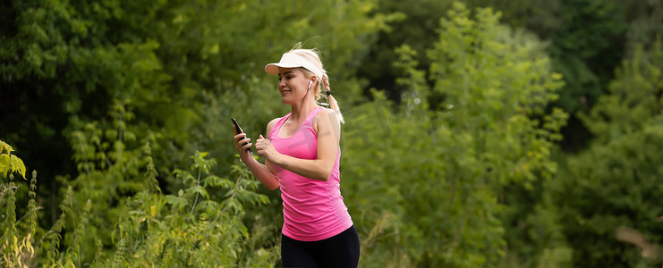 乡村大自然中听音乐的健身运动女跑步者