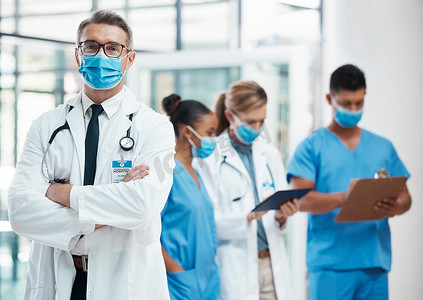 医生、护理人员和保健护士戴着新冠口罩站着，以确保他们在医院的安全。