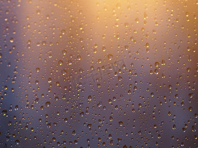 水和雨滴在玻璃上的复古色调，抽象视图，蓝色玻璃背景上的雨滴雨后滴在玻璃上。