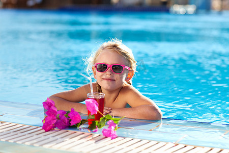 喝果汁的女孩摄影照片_在泳池里喝鸡尾酒的女孩