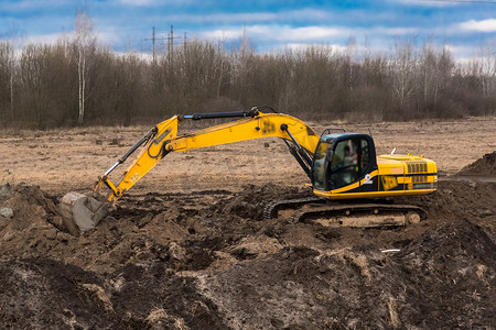 挖掘机cad摄影照片_履带式挖掘机在工业区或建筑工地挖土