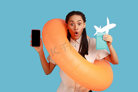女人拿着橙色橡胶圈、纸飞机和手机，屏幕空空，出国度假。
