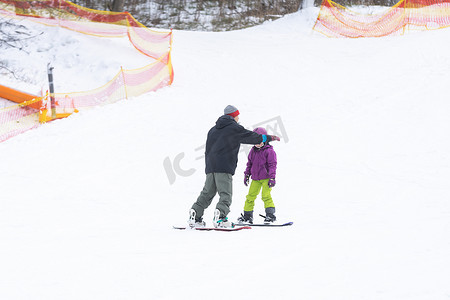 滑雪场父亲教小女儿滑雪