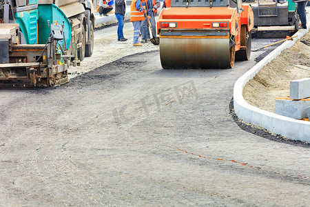 一摊摄影照片_大型重型道路设备正在修建一条新的沥青路。
