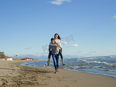 秋天在海滩上玩耍的情侣