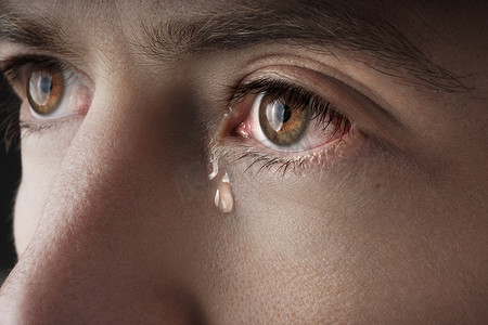 年轻哭泣的男人眼睛含泪的特写镜头