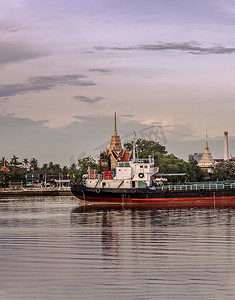 湄南河的景色有货船停靠在河中，后面是 Wat Bangkrachaonok 地区。